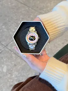 Détail d'une montre chat de dessin animé présentée dans une boîte cadeau hexagonale.