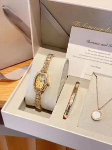 Coffret cadeau montre vintage et bijoux dorés dans une boîte blanche haut de gamme.