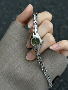 Détail d'une montre à quartz vintage pour femme avec cadran olive et bracelet argenté