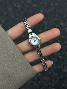 Détail d'une montre à quartz GEDI argentée de style vintage pour femme sur une main.