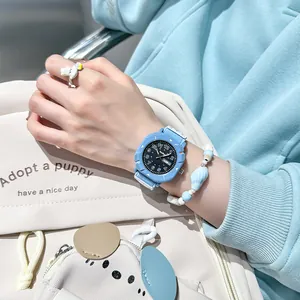 Student quartz watch with blue canvas strap and black dual calendar dial on wrist