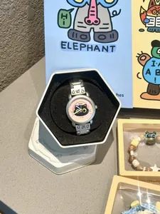 Vue détaillée d'une montre chat de dessin animé dans une boîte cadeau hexagonale.