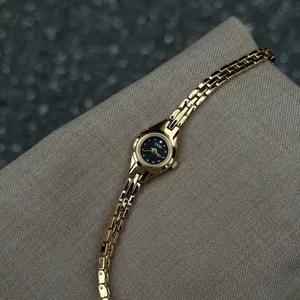 Montre bracelet vintage dorée pour femme avec cadran noir et design minimaliste chic