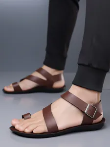 Detailed view of brown men's sandals featuring a toe loop and adjustable buckle strap