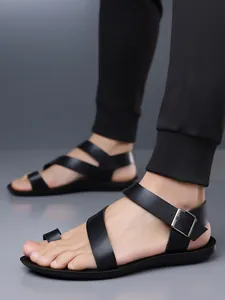 Detail of black leather men's sandals with toe loop and adjustable ankle buckle.
