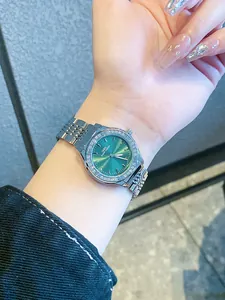 Detalle del reloj de lujo plateado IBSO con esfera verde con efecto rayo de sol en la muñeca