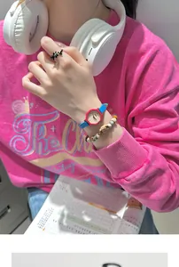 Detailed view of an octagonal color-block quartz watch on a wrist with stylish accessories