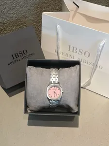 Detalle de un reloj cuadrado minimalista de acero plateado con esfera rosa en caja