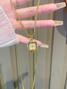 Detail of vintage square gold pocket watch pendant with a delicate fine box chain.