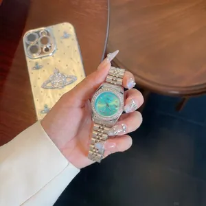 Elegante reloj de cuarzo para mujer con bisel de pedrería y esfera turquesa