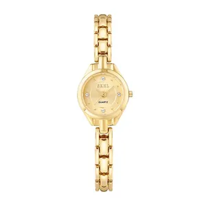 Montre bracelet vintage dorée pour femme avec un cadran minimaliste serti de diamants.