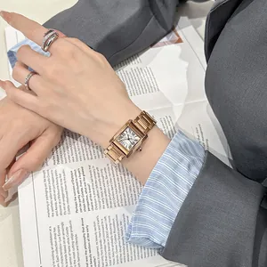 Primo piano di un elegante orologio quadrato in oro rosa con numeri romani e anelli