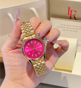 Dettaglio di orologio in acciaio dorato con quadrante magenta brillante