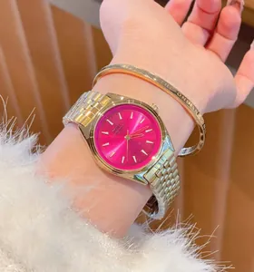 Elegante orologio da donna in oro con quadrante rosa vivace presentato al polso