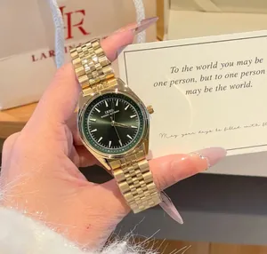 Vista dettagliata dell'orologio al quarzo dorato con quadrante verde e elegante biglietto.