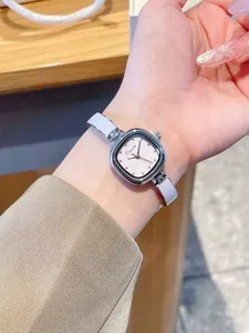 Vue rapprochée d'une montre bracelet carrée élégante et minimaliste pour femme au poignet