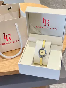 Détail d'une montre-bracelet carrée élégante pour femme avec un bracelet jaune dans son coffret