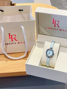 Gros plan d'une montre bracelet carrée bleu clair dans un coffret cadeau