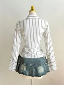 Back view of pinstriped long-sleeve shirt with pleated denim mini skirt on mannequin