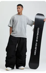 Professional loose black snowboarding pants with high waist shown on a male model