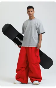 Professional loose-fit red waterproof snowboarding pants displayed on a male model