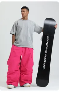 Professional loose fit bright pink waterproof snowboard pants for men and women on model.