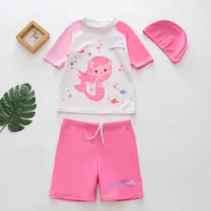 Three-piece pink girls mermaid swimsuit set with cartoon print, shorts, and swim cap