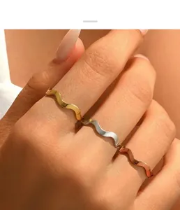 Detailed view of three stackable wavy rings in gold, silver, and rose gold plating.