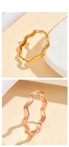 Macro view showing the high-polished texture of gold and rose gold wavy steel rings
