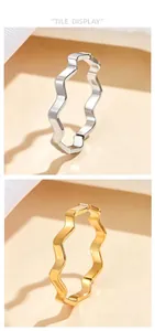 Detailed display of minimalist wavy stainless steel rings in polished gold and silver.