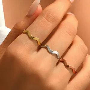 Minimalist wavy stackable stainless steel rings in gold, silver, and rose gold finishes.