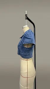 Vista laterale dettagliata di una giacca di jeans corta a maniche corte su un manichino.