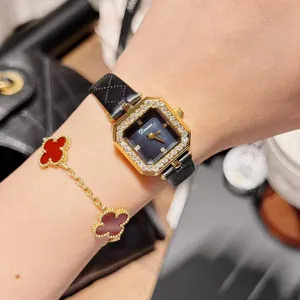 Close-up of elegant Dinimi square gold watch with black quilted leather strap on wrist