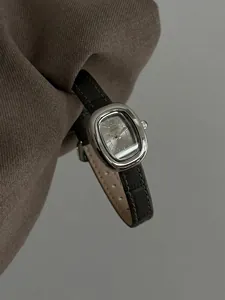 Nahaufnahme der GUOU Vintage Quarzuhr für Damen mit einem schwarzen Lederarmband