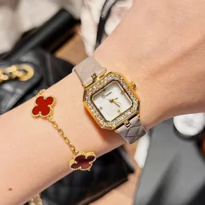 Detail view of Dinimi square watch with quilted grey strap and rhinestone bezel