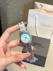 Detalle del reloj de acero plateado con esfera cuadrada verde menta y logotipo de IBSO