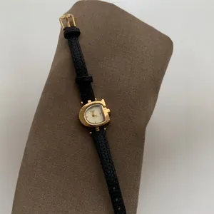 Elegante reloj de cuarzo vintage para mujer con caja dorada en G y correa de cuero.
