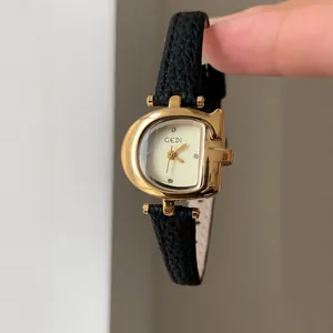 Primer plano del reloj GEDI para mujer con caja dorada en forma de D y correa de cuero