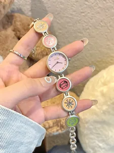 Detailansicht einer süßen silbernen Armbanduhr mit Cartoon-Anhängern für Mädchen.