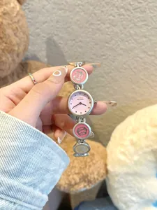 Detaillierte Makroansicht einer silbernen Armbanduhr mit rosa Zifferblatt und Katzenmotiven