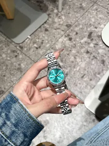 Detailansicht der Dinimi Damenuhr mit türkisem Zifferblatt und Strass-Lünette