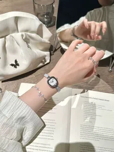 Élégante montre carrée en sucre avec bracelet en argent portée au poignet avec bijoux