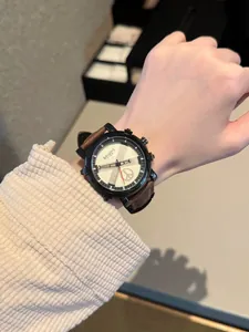 Close-up view of a stylish unisex quartz watch with brown leather strap on wrist