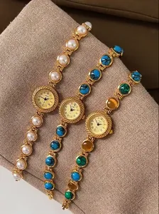 Détail de trois montres bracelets vintage dorées avec incrustations de perles et turquoise