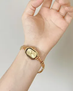 Close-up of an elegant vintage style gold steel watch worn on a woman's wrist