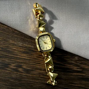 Detail of vintage gold quartz watch featuring a unique geometric geometric bracelet band