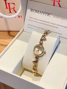 Detailed view of vintage gold ladies watch with geometric steel strap in elegant gift box