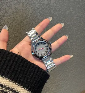 Primo piano di un orologio al quarzo minimalista in argento con quadrante grigio in mano