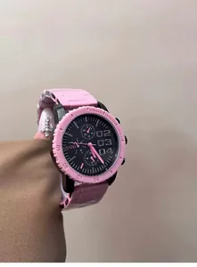 Primer plano de reloj deportivo rosa y negro para mujer con esfera grande y correa silicona