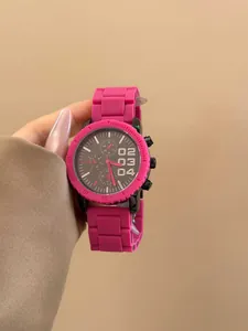 Vista detallada de un moderno reloj de cuarzo rosa con esfera grande y correa de silicona